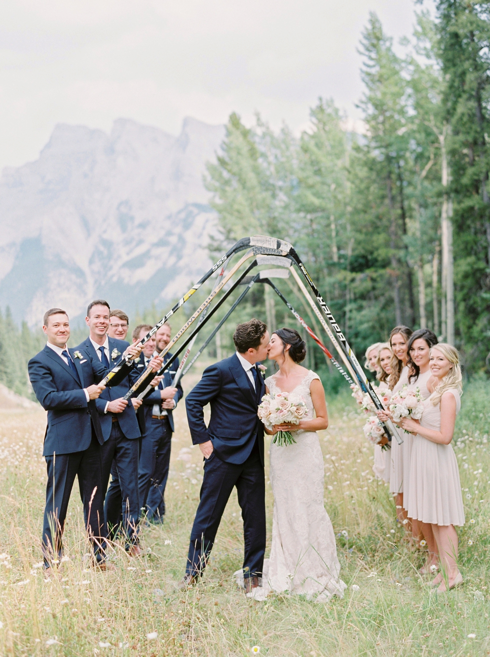 Canadian hockey wedding | wedding bridal party photograph with hockey sticks | Banff springs wedding photographers | fairmont banff rocky mountain wedding | Justine Milton fine art film Photography