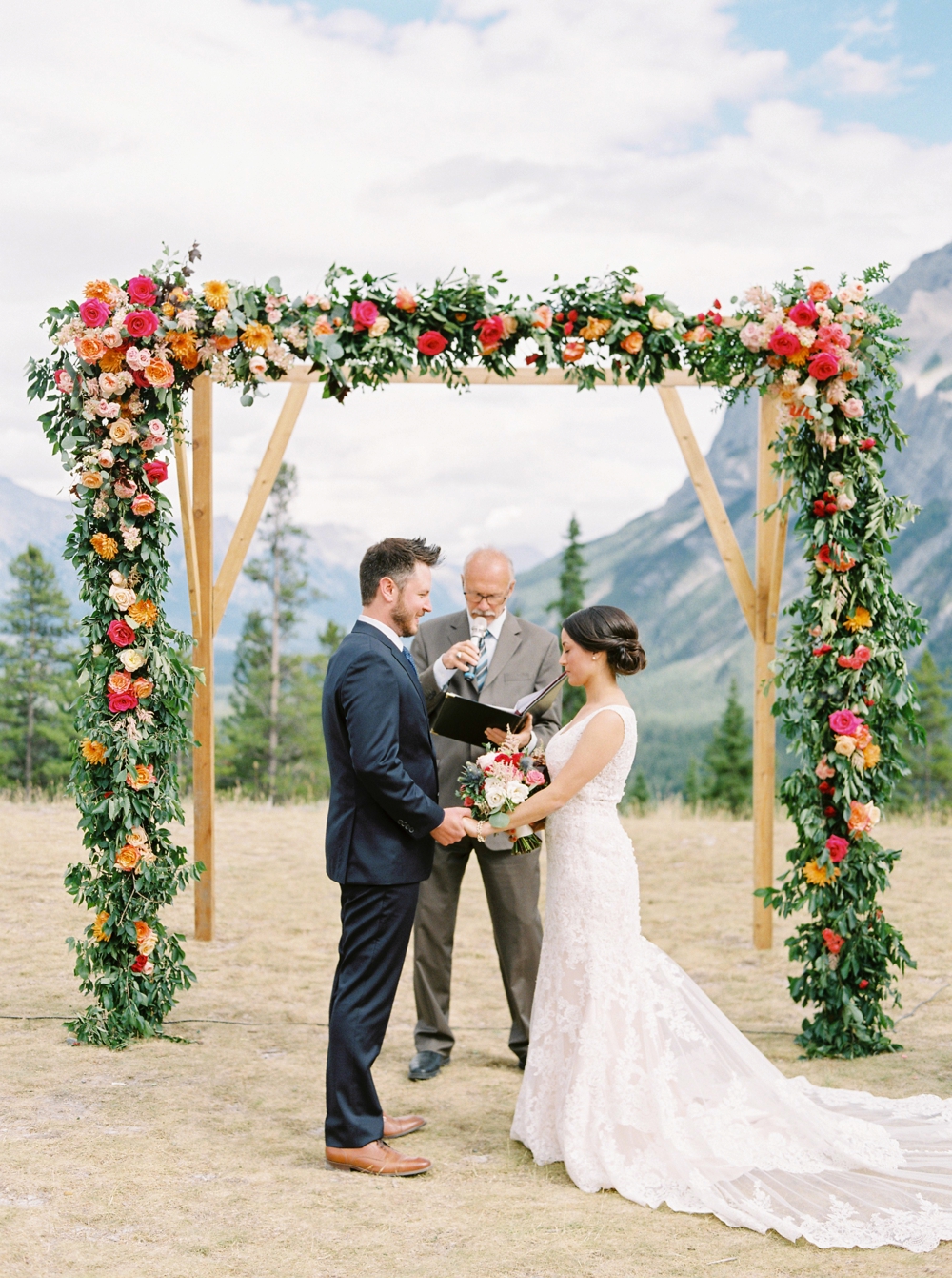 Banff Wedding Photographers | Banff tunnel mountain reservoir | wedding ceremony decor brightly colored floral arch | Justine Milton fine art film photographers