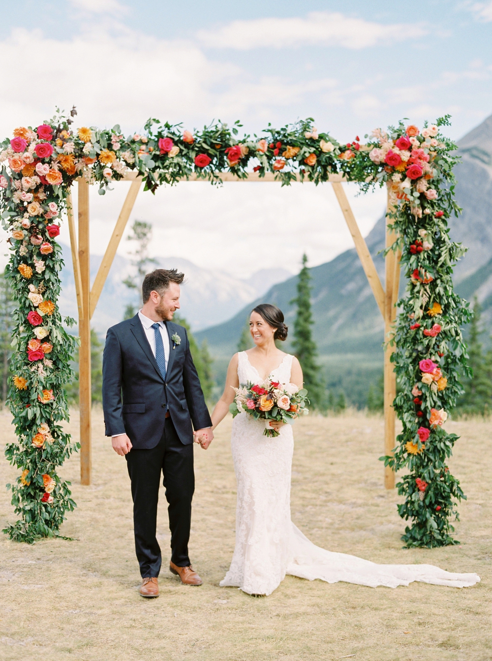 Banff Wedding Photographers | Banff tunnel mountain reservoir | wedding ceremony decor brightly colored floral arch | Justine Milton fine art film photographers