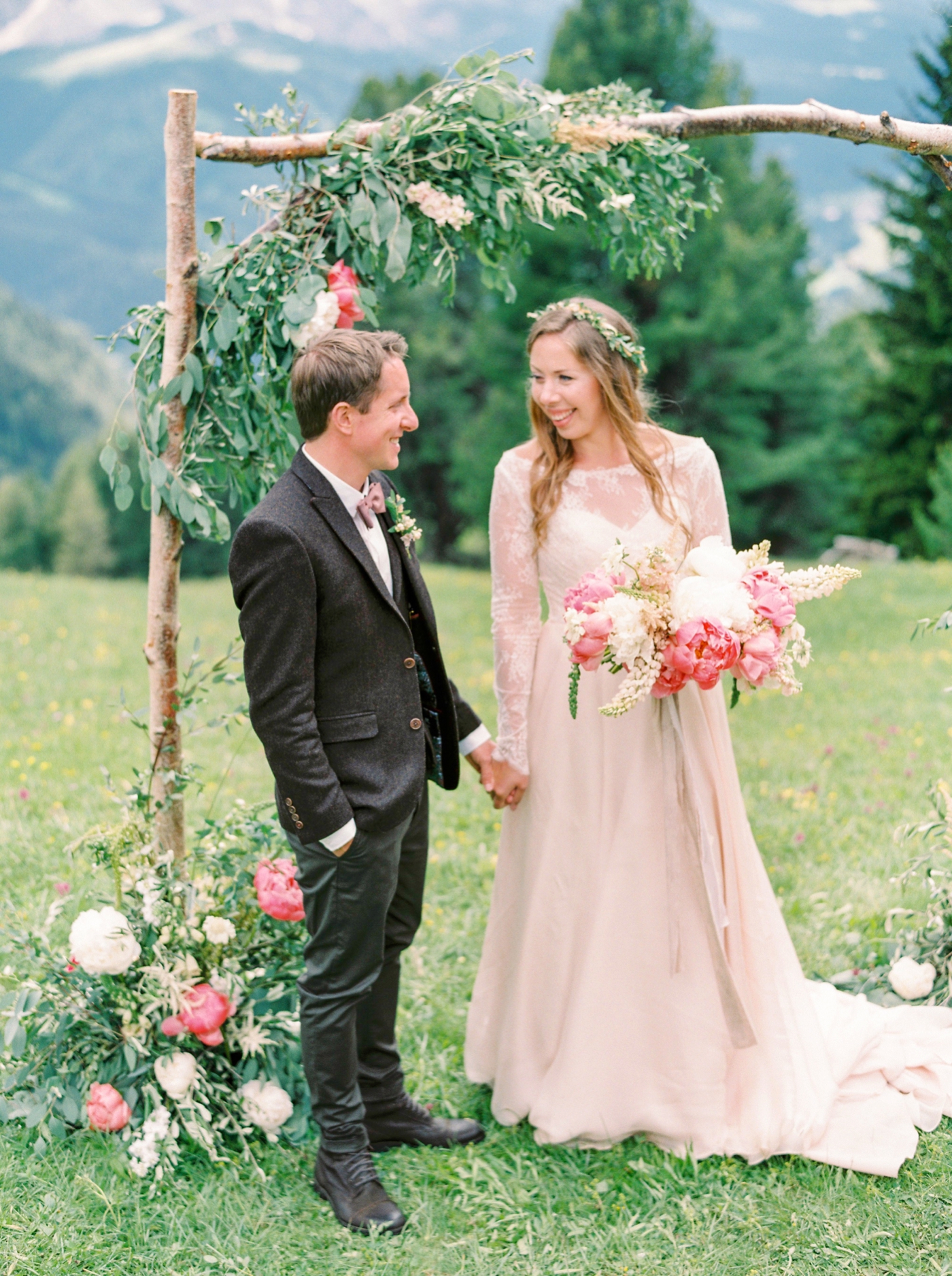 Italy wedding photographers | Dolomites mountain top wedding | pink and white peony bouquet | long sleeve flowing wedding dress | outdoor wedding ceremony ski chalet wedding floral arch | justine m...