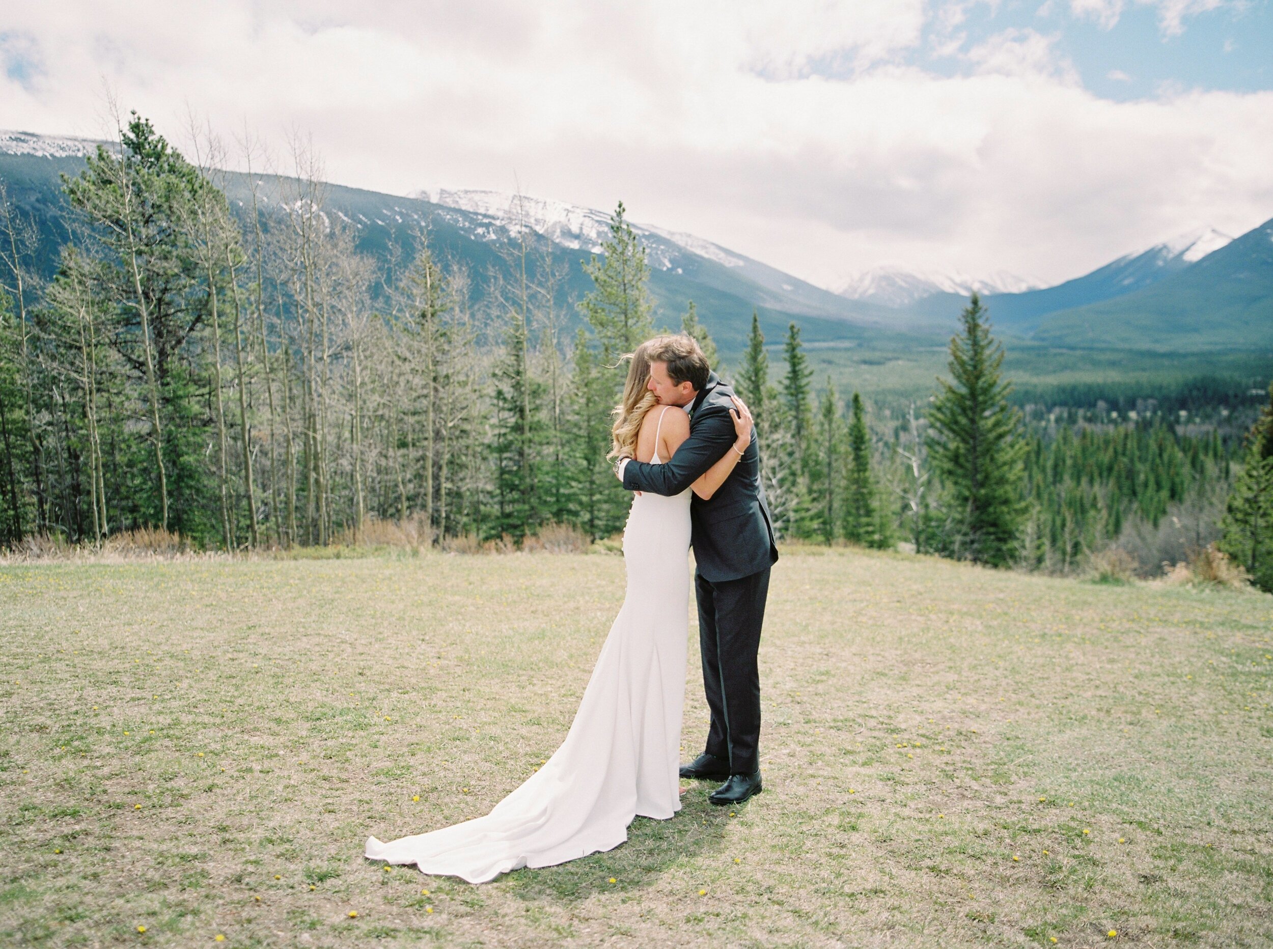  first look passionate hug on the side of a mountain | Kananaskis wedding | fine art film Banff wedding photographer 