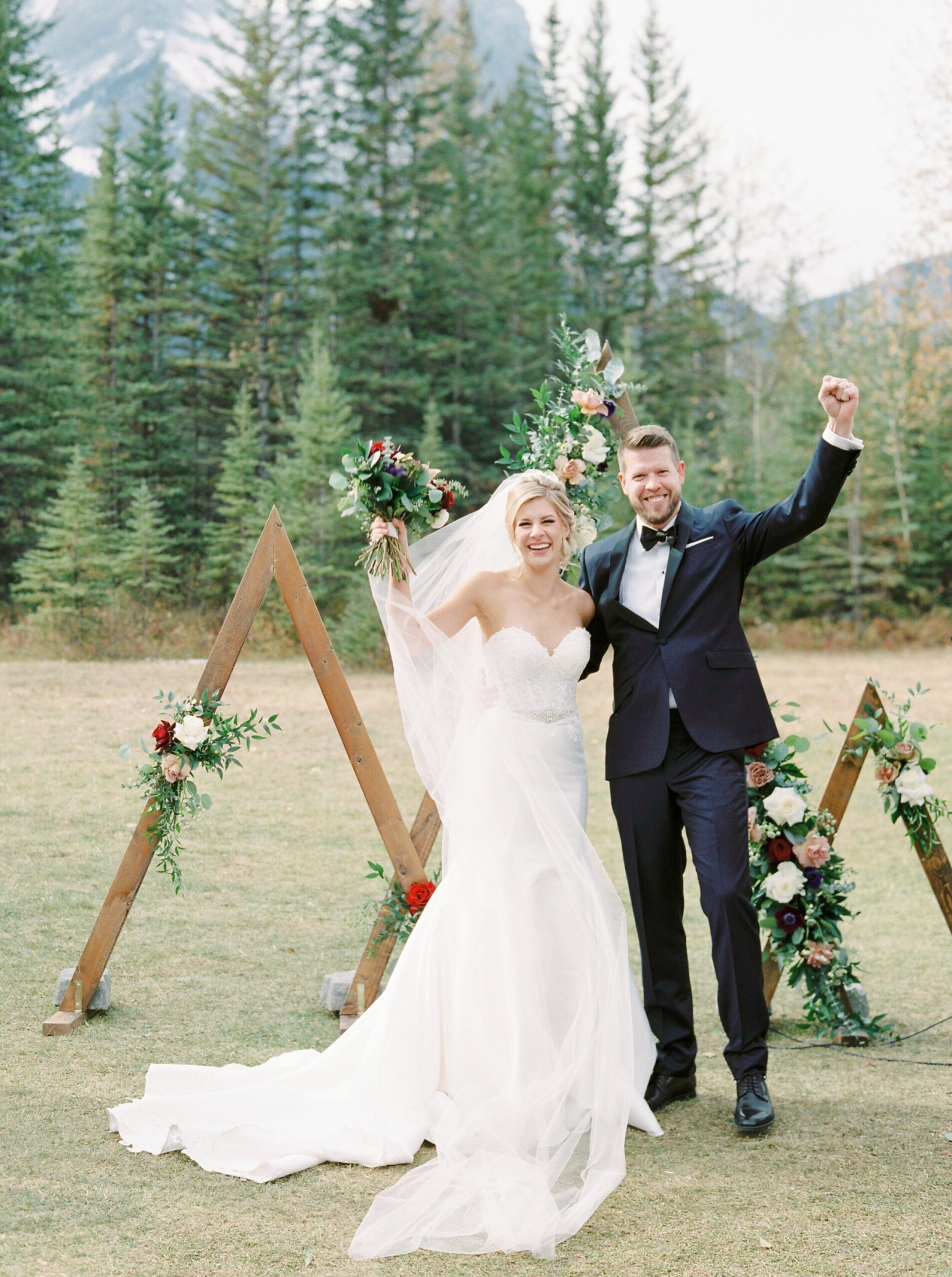 YAY we're married | best reaction photos | Outdoor mountain ceremony with a triangle floral arch | Cornerstone Theater & Canmore Ranch Wedding Photographers 