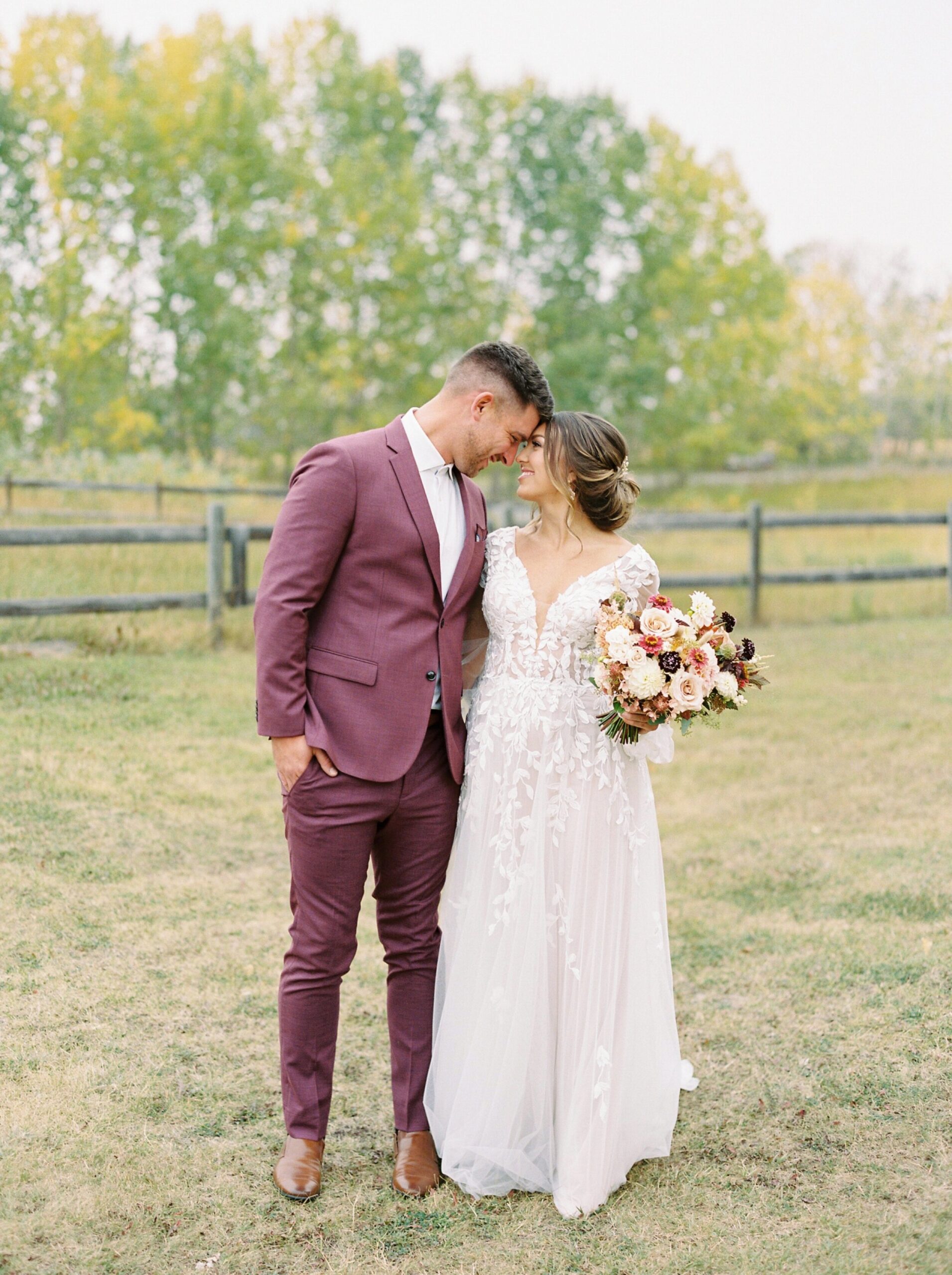  wedding couple pose ideas | different colored suits | red burgandy suit | warm tone wedding editorial in okotoks at Primrose Lifestyle | calgary fine art film wedding photographer 
