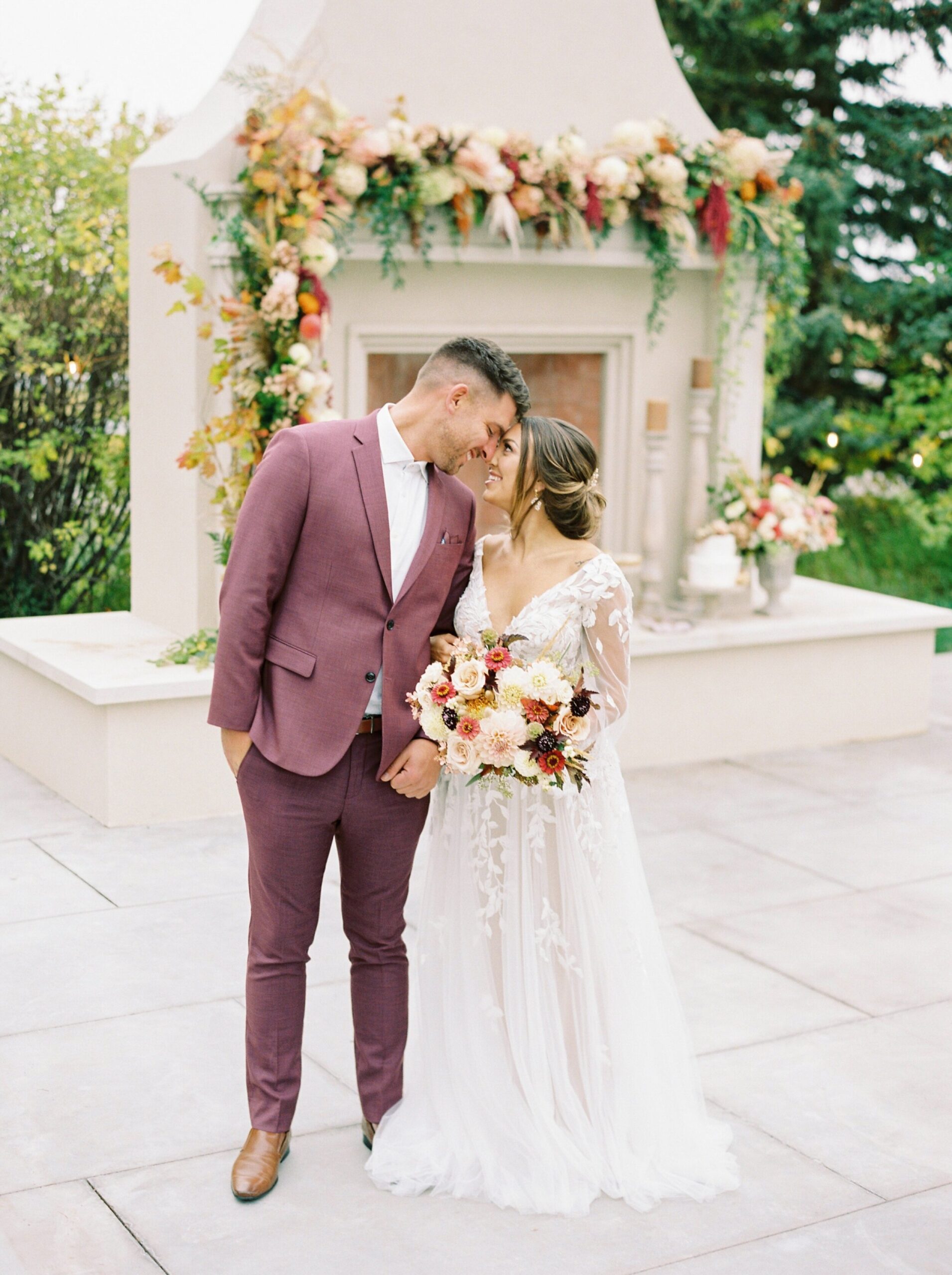  wedding couple pose ideas | different colored suits | red burgandy suit | warm tone wedding editorial in okotoks at Primrose Lifestyle | calgary fine art film wedding photographer 
