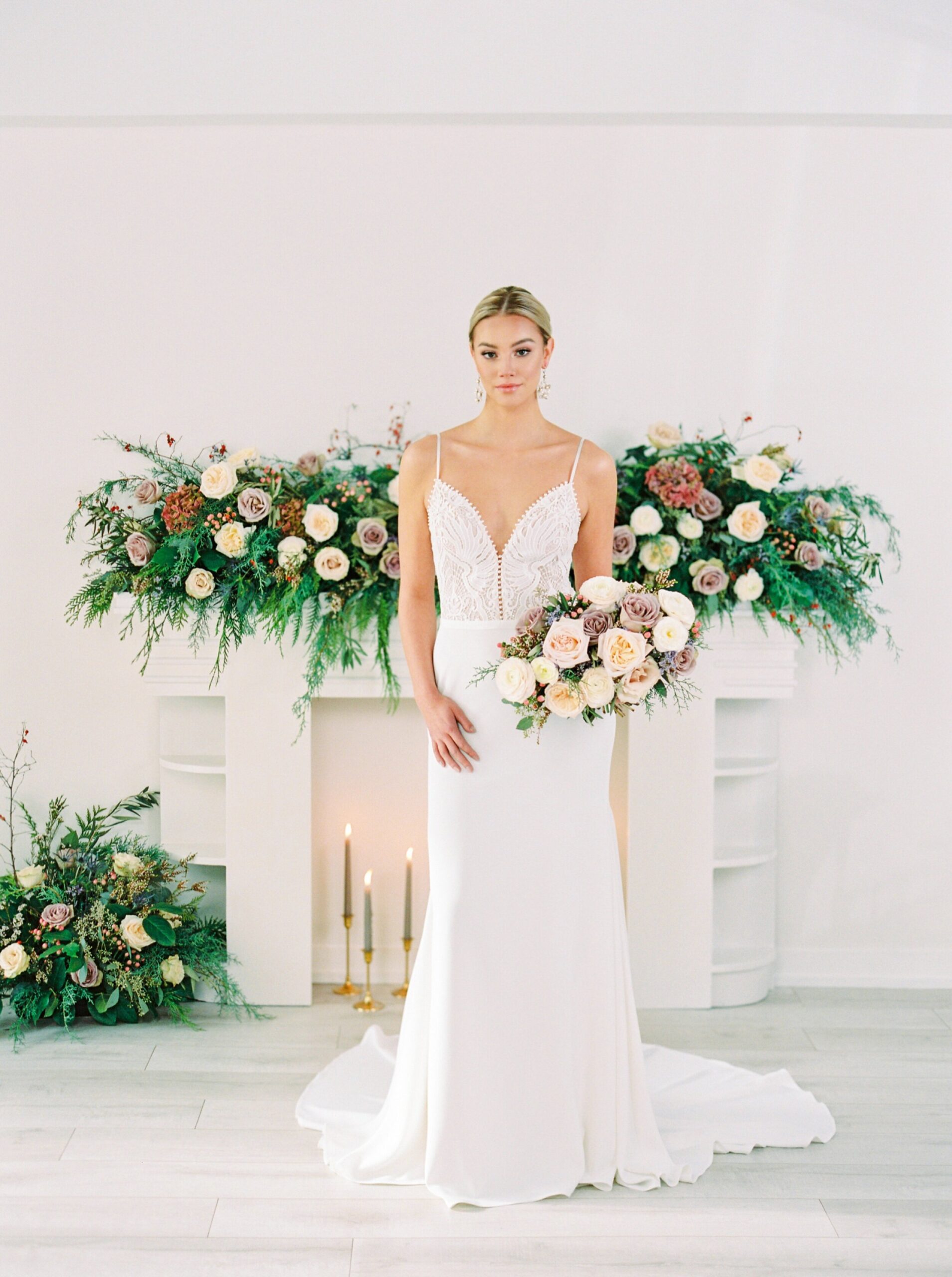  fitted wedding dress inspiration | fine art flower installation with greenery above fireplace | modern bridal bouquet with dusty pinks and roses 
