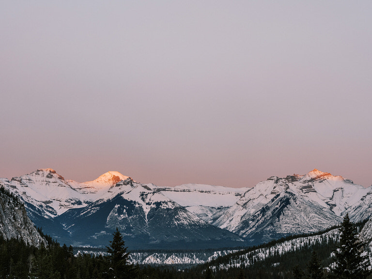 Sunset creates beautiful pink sky with orange mountain peaks in Banff, Canada