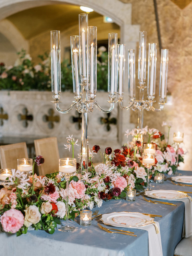 wedding reception table settings featuring candles, florals, and place settings in the color pallet of blue and gold with pink, white and red accents at Banff Springs Hotel 