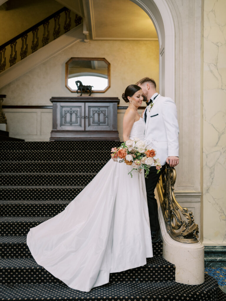 bride and groom on staircase at hotel fairmont palliser in calgary
