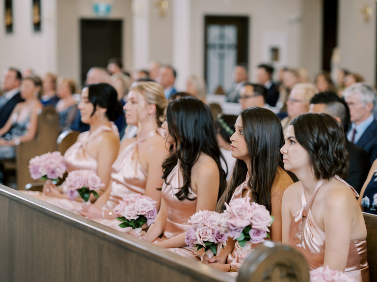 Bridesmaids seated at wedding ceremony