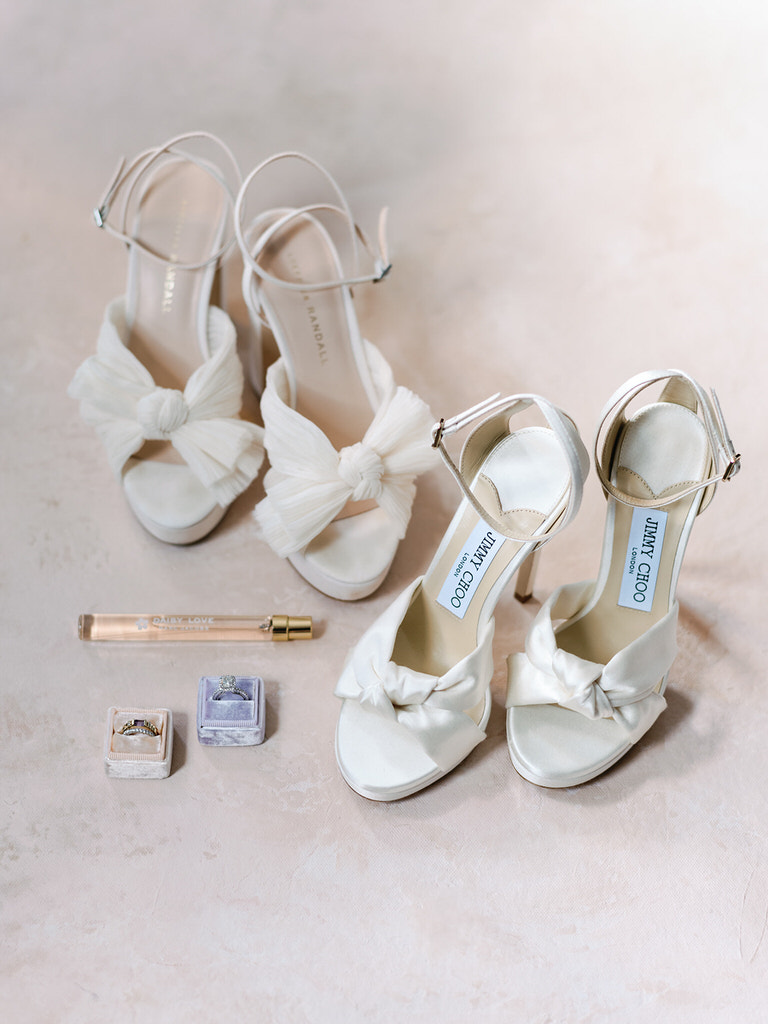 bridal flaylay with white open toed heels, perfume, and wedding rings