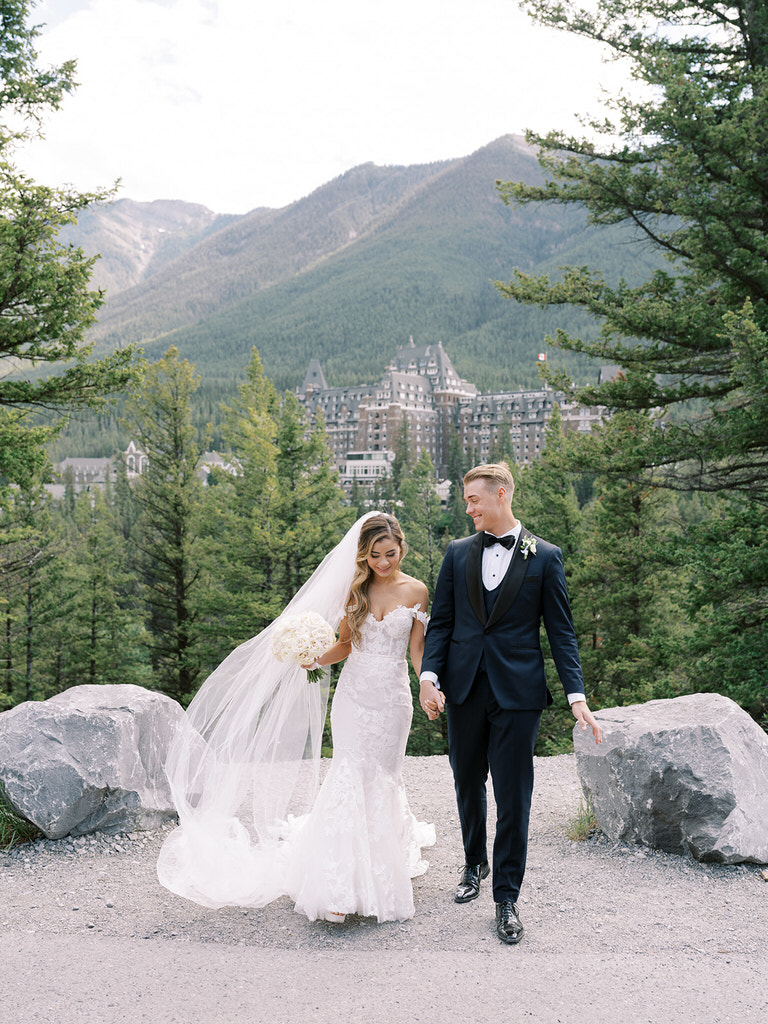 Bride and Groom wedding portrait in Canadian Rockies with mountains, forest and iconic Fairmont Banff Spings Hotel