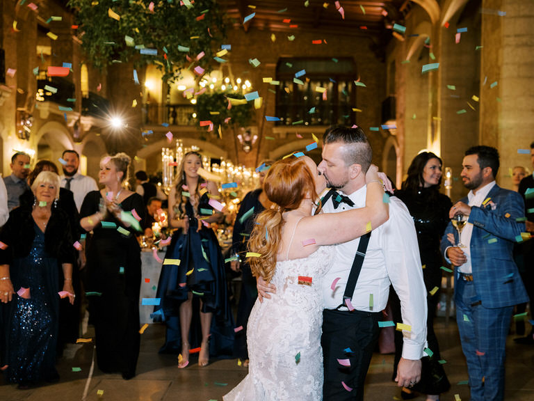 Bride and Groom kiss during first dance, confetti falls around them at Banff Springs Hotel 