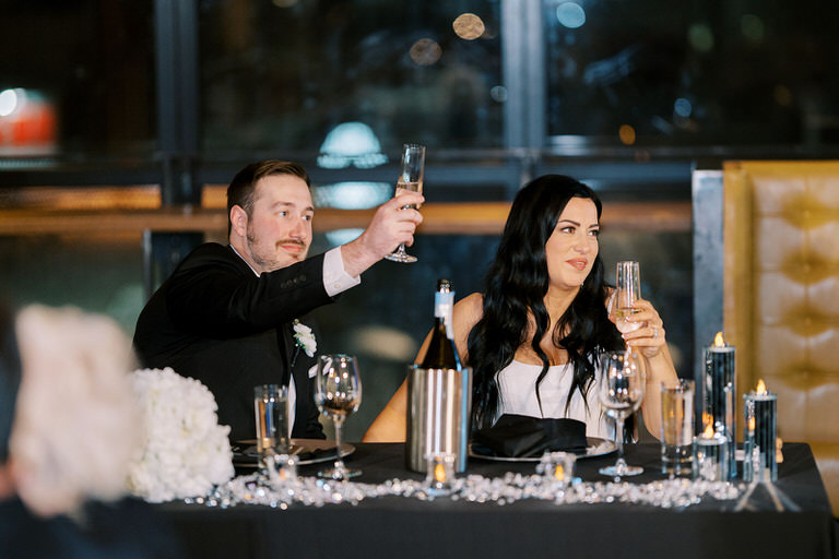 Bride and Groom raising to a toast at head table for wedding in Calgary, Alberta
