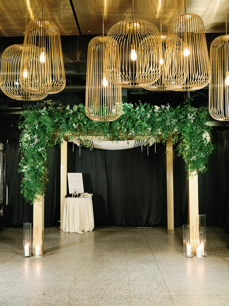 Tradirional jewish ceremony canopy - chuppah with green foliage and gold accents