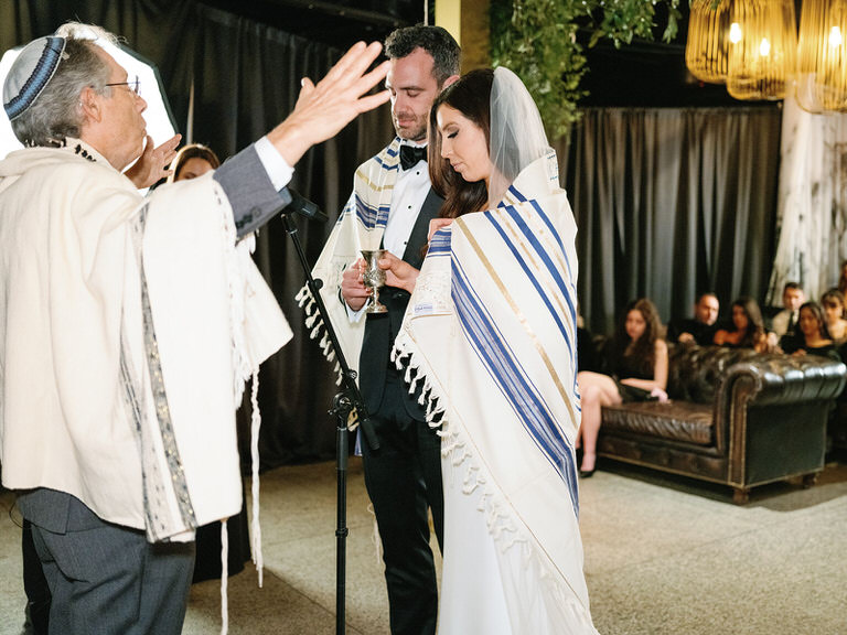 bride and groom under the chuppah during jewish wedding ceremony 