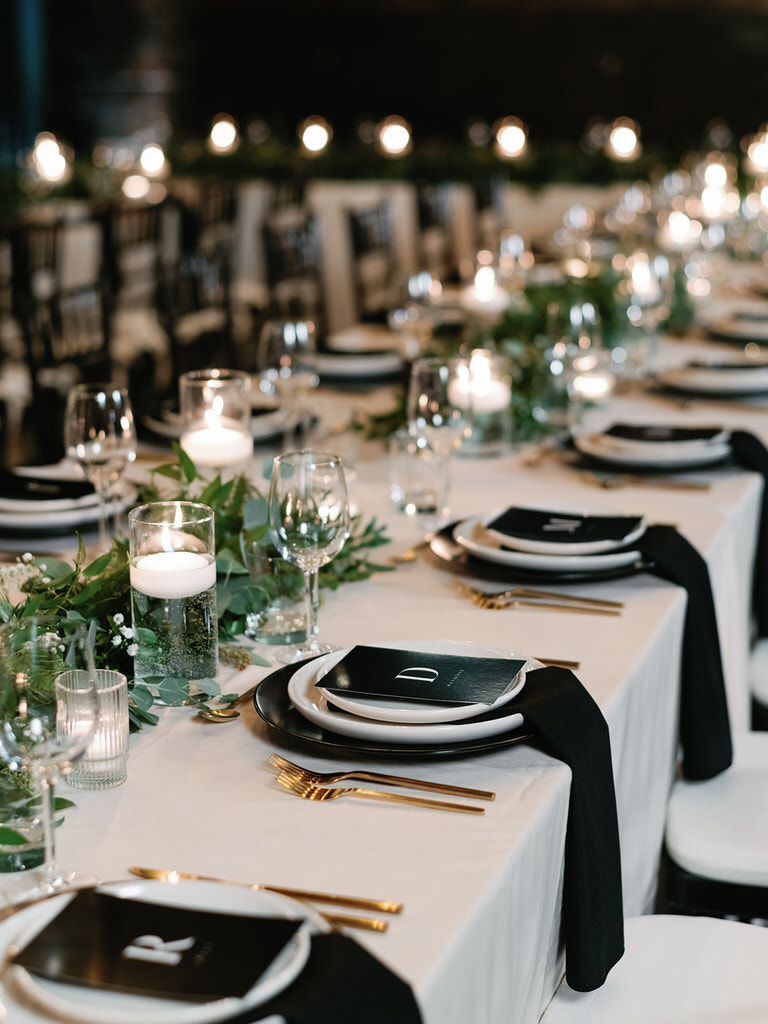 Wedding recerption - table settings with green foliage, black and gold details