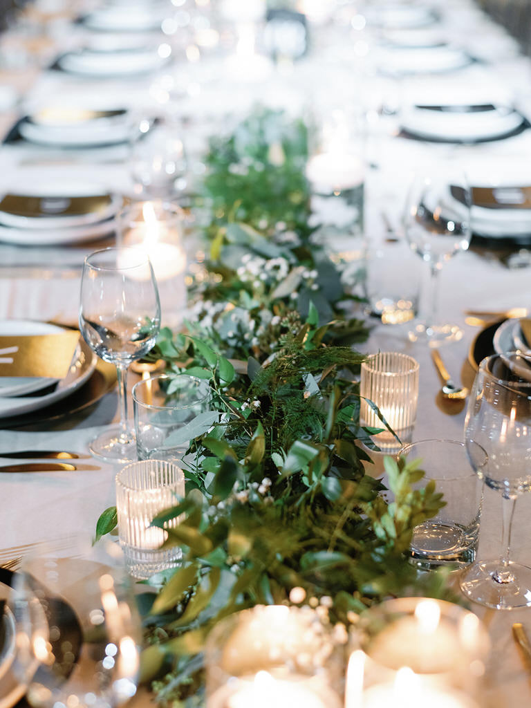 Wedding recerption - table settings with green foliage, black and gold details