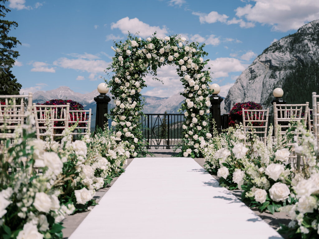Wedding ceremony decor, outdoor wedding with white florals and green arches. Banff Springs Fairmont Hotel  