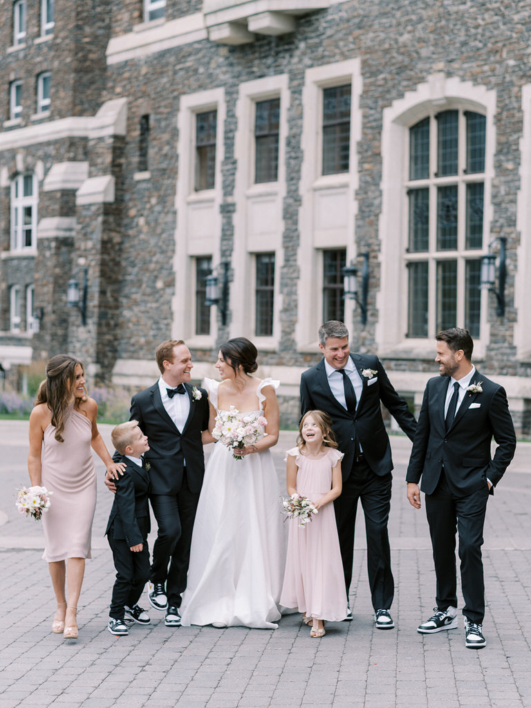 Bridal party portrait, best man, maid of honour, flowergirl. BLush pink wedding colors, wedding florals of light pink and white.  Fairmont Banff Springs Hotel in background. 
