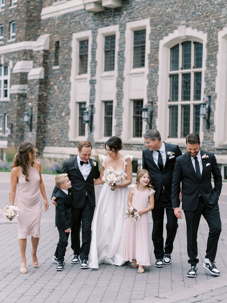 Bridal party portrait, best man, maid of honour, flowergirl. Blush pink wedding colors, wedding florals of light pink and white.  Fairmont Banff Springs Hotel in background. 