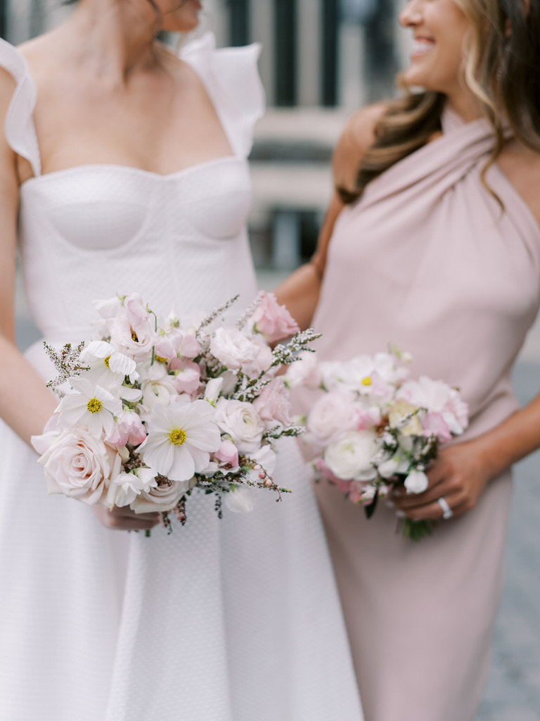 Bridal party portrait, bride and maid of honour. Blush pink wedding colors, wedding florals of light pink and white.  Fairmont Banff Springs Hotel in background. 