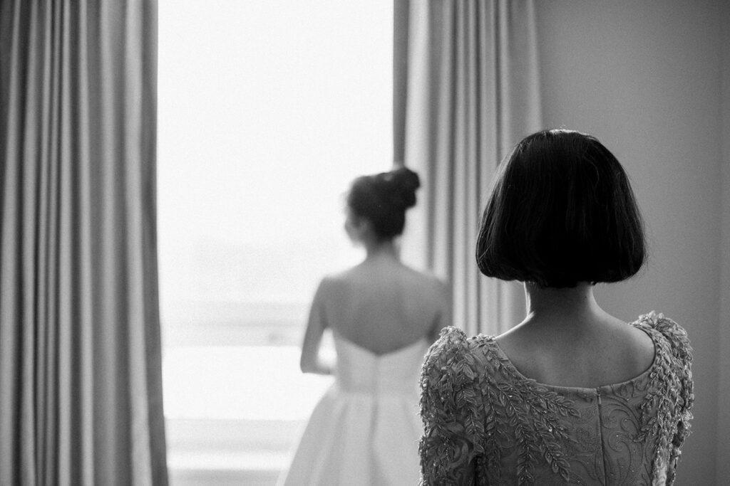 Bride getting ready, mother-daughter first look. Black and white wedding photography