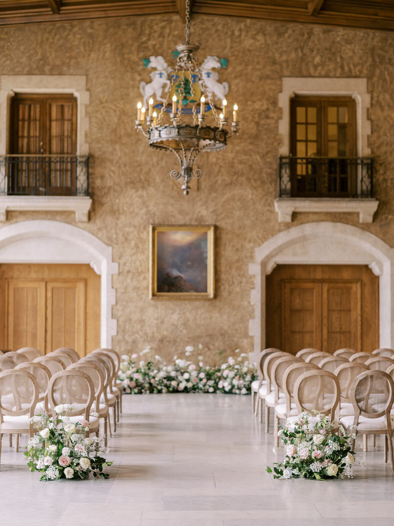 wedding ceremony space in Fairmont Banff Springs hotel. Beige and white rattan chairs with pastel light pink and light florals. 