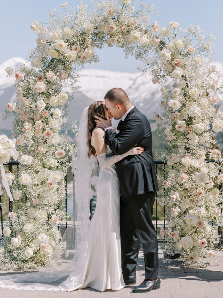 modern babys breath and roses wedding ceremony floral arch at the Fairmont Banff Springs Hotel captured by Banff wedding photographer Justine Milton
