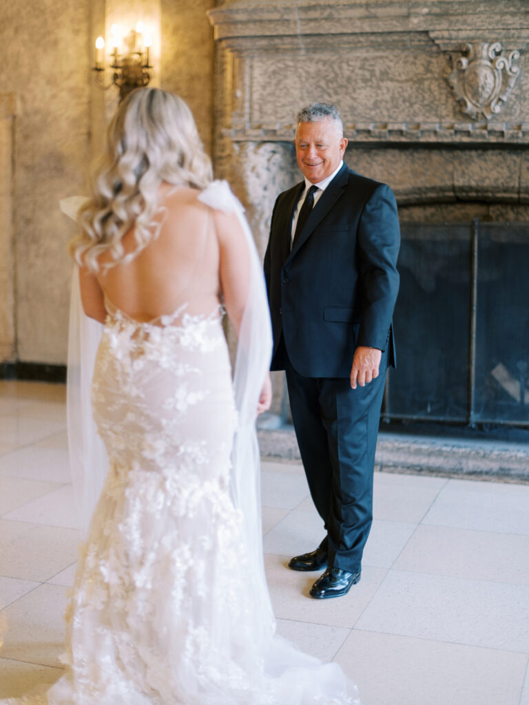 brides first look with dad in front of fire place at the Fairmont Banff Springs captured by Banff Wedding Photographer Justine Milton