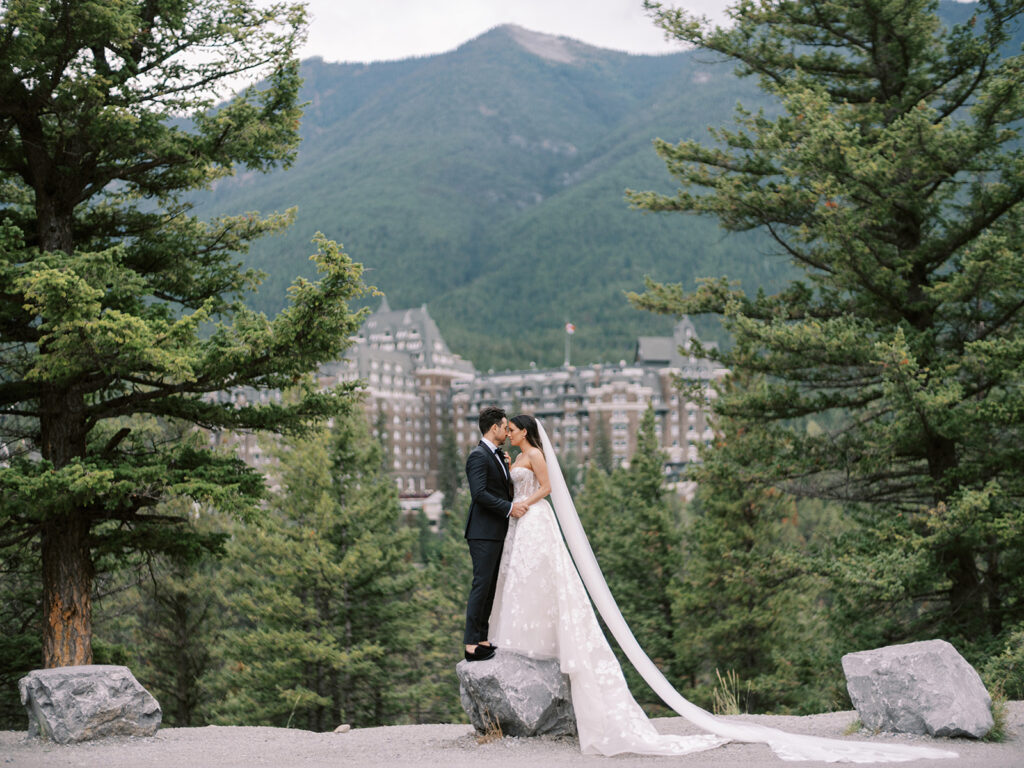 Banff wedding photographer captured bride and groom in front of the Fairmont Banff Springs Hotel, castle in the rockies.