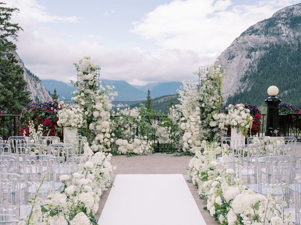 Fairmont Banff Springs Hotel terrace set up for a ceremony with stunning all white florals captured by Banff Wedding Photographer Justine Milton