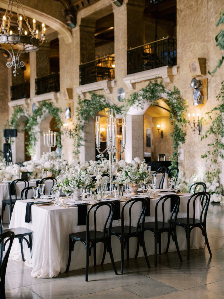 Mt. Stephen Hall at the Fairmont Banff Springs. Stunning wedding reception decor with chic black chairs and all white florals in a castle in the rocky mountains.