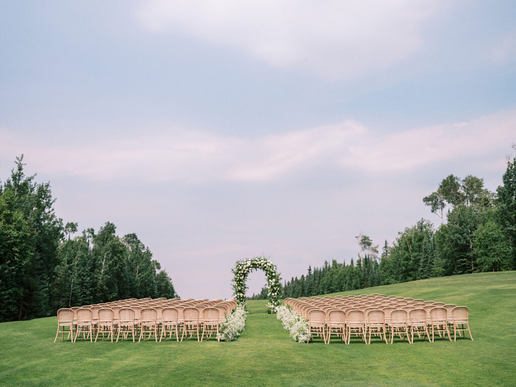 Elk Ridge Resort in Saskatchewan set up for a stunning ceremony with floral hedges and arch on the golf course for tasha and chandler stephensons wedding captured by Canadian and destination wedding photographer Justine Milton
