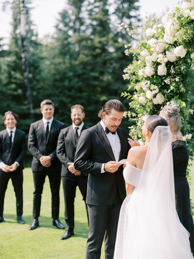 groom sharing personal vows with bride at ceremony on the golf course at elk ridge resort captured by Canadian and destination wedding photographer Justine Milton