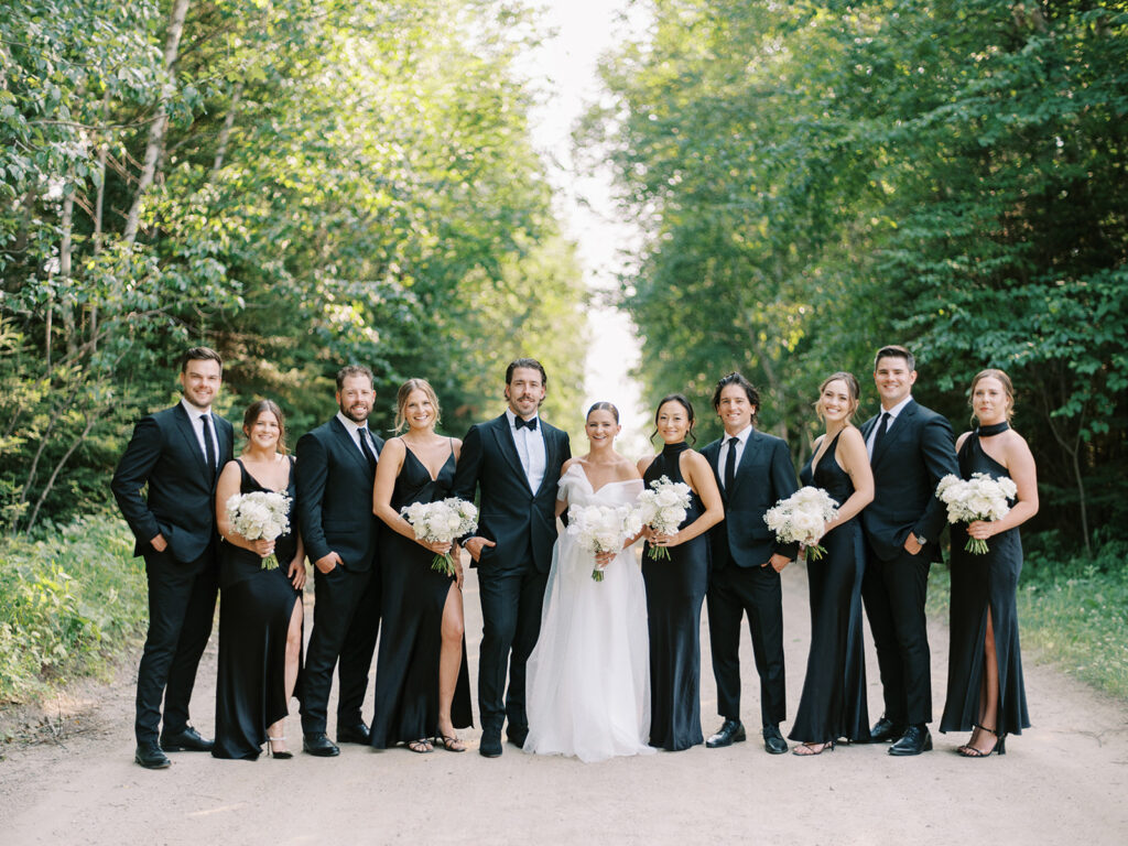 chic wedding party in all black with white florals at The Stephenson wedding at Elk Ridge Resort captured by Canadian and destination wedding photographer Justine Milton