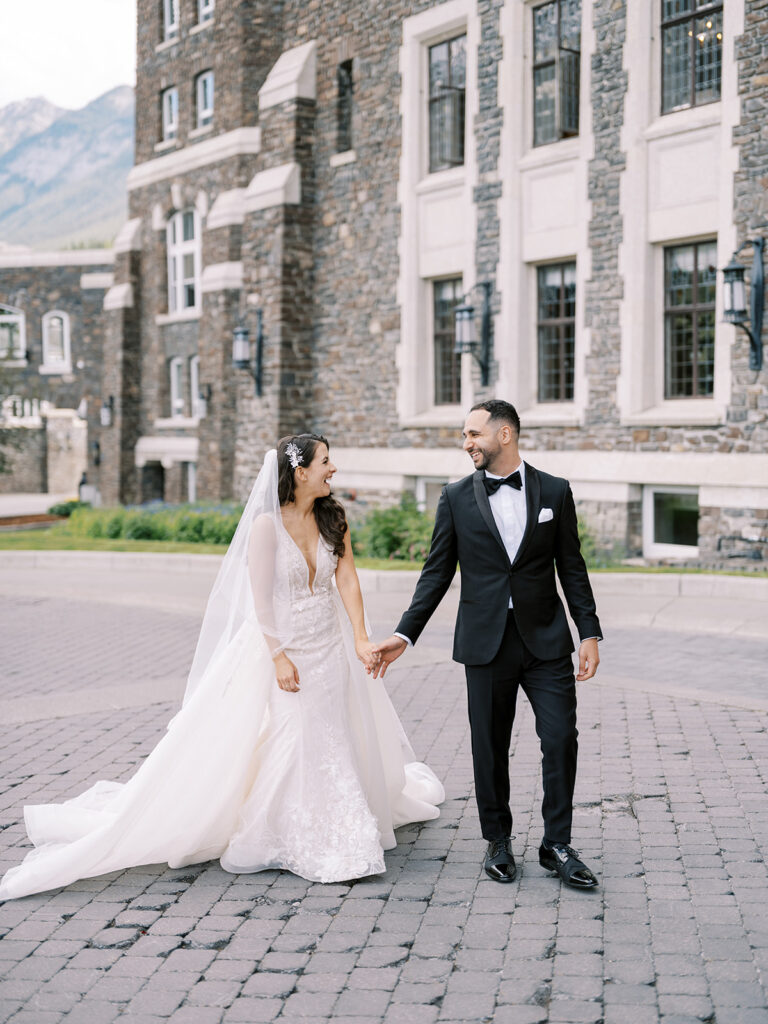 Banff photographer captures bride and groom walking in the entrance of the stunning Castle in the rockies, the Fairmont Banff Springs